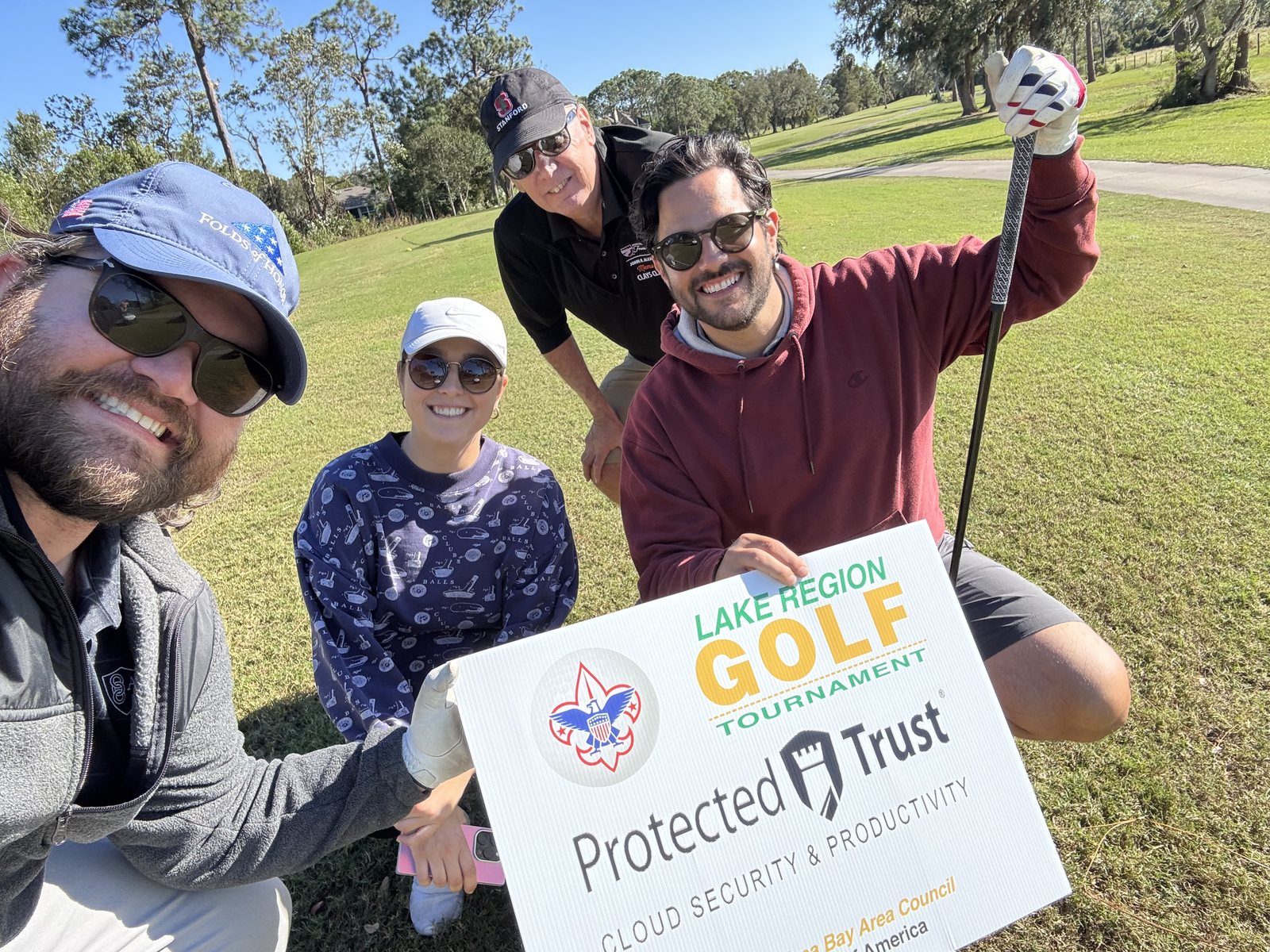 Our foursome with the tournament sign