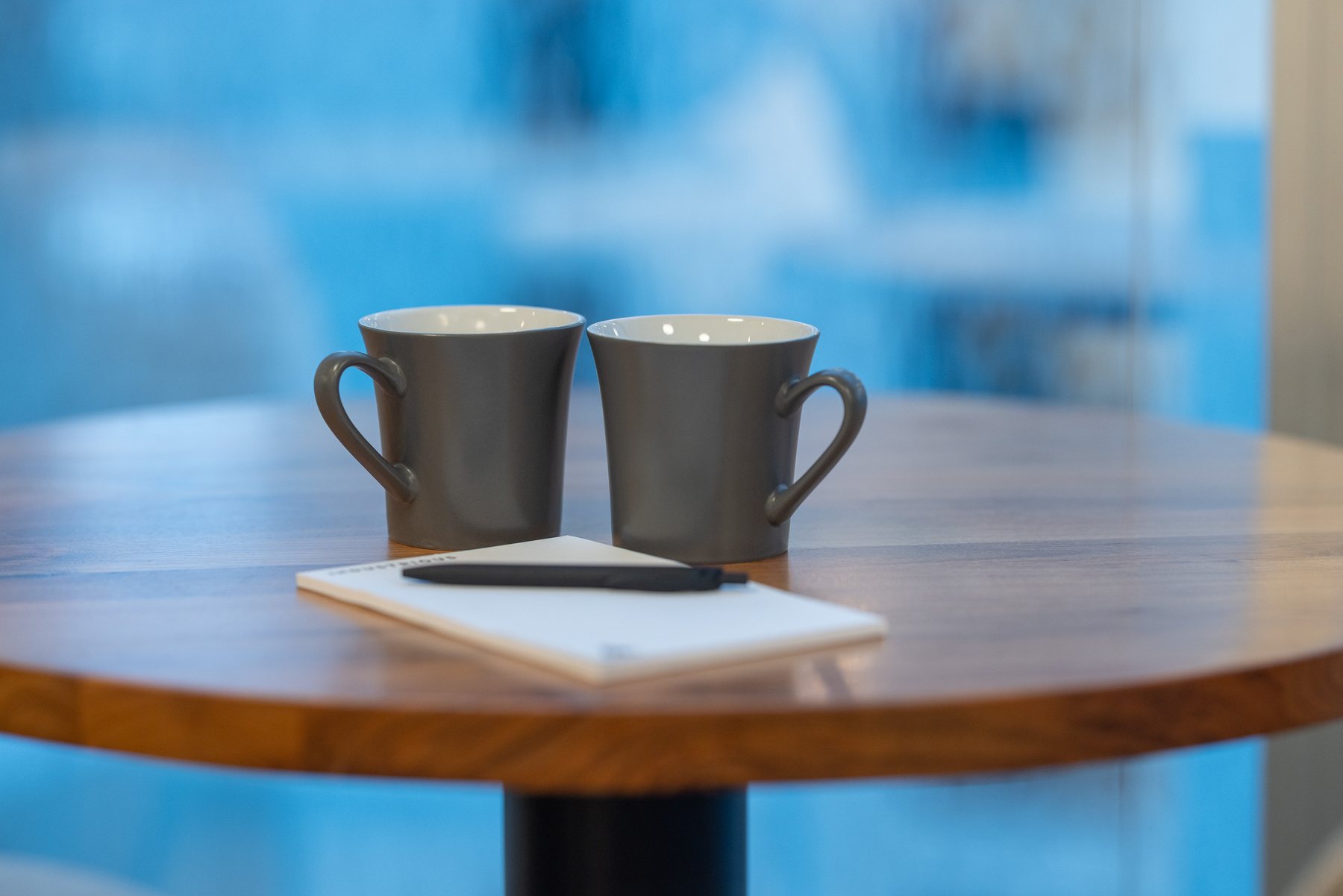 A notebook and two cups on the table