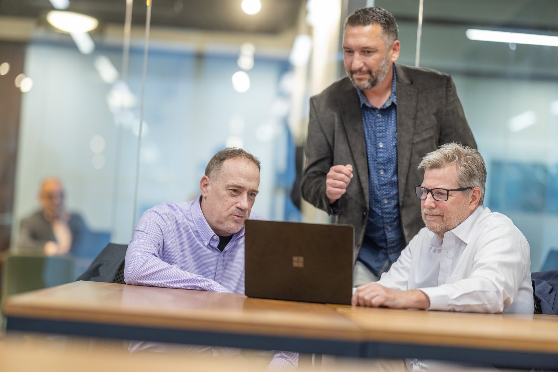 Three of the team at one laptop