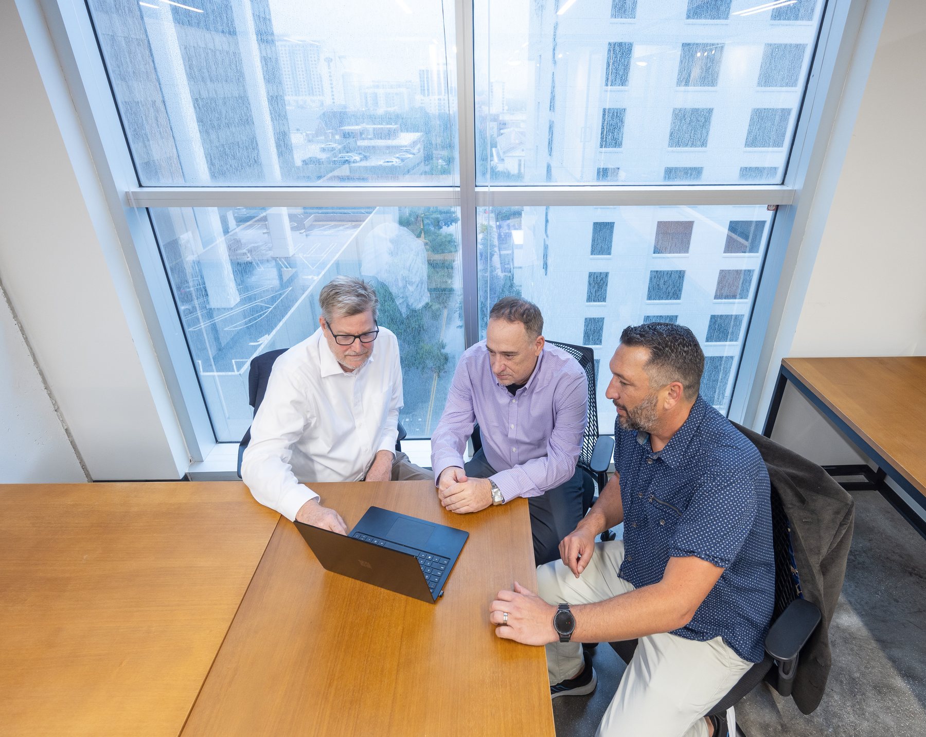 Three of the team at the window table, Tampa behind them