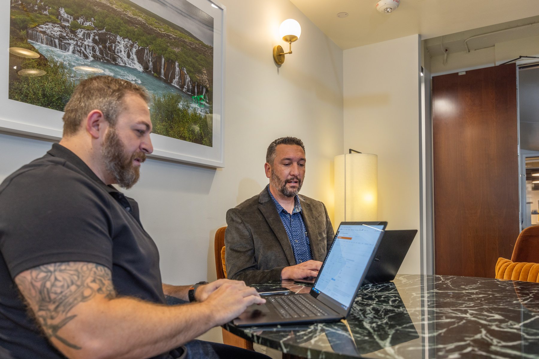 Two of the team in the library chairs, laptops open
