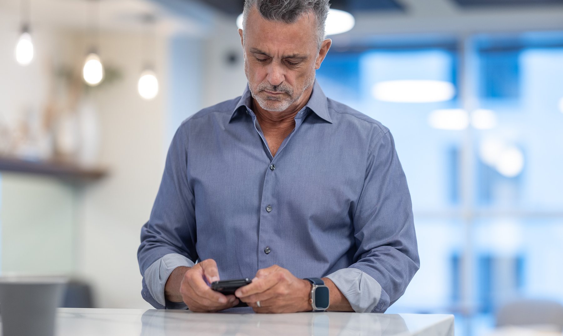 Javier with his phone at the counter